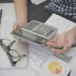 business accountant with document graph financial and calculator on office table. concept planning budget and audit.