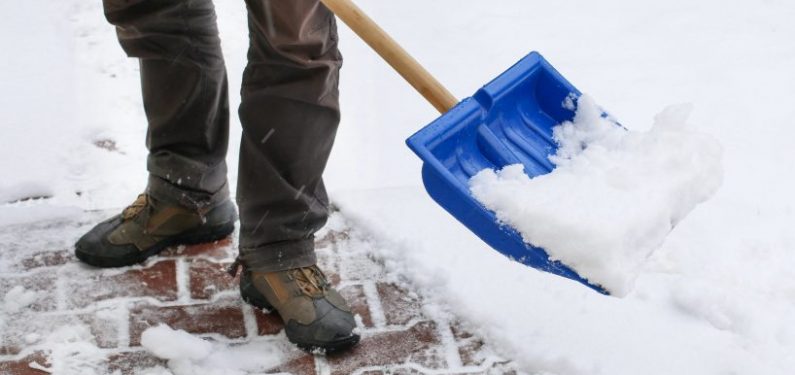 avoid an insurance claim - man clearing sidewalk after snow