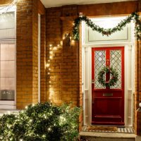 front of a home decorated for christmas