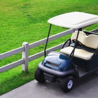 golf cart parked next to a fence