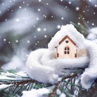 toy house covered in snow and wrapped in a scarf