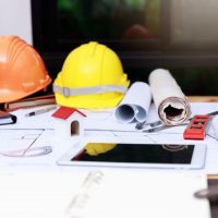 hard hats, blueprints, and designs on a table