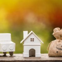 small cardboard car and house and a small canvas money bag