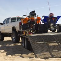 pickup truck and trailer with quads on a beach