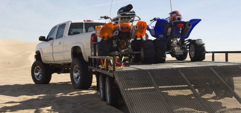 pickup truck and trailer with quads on a beach