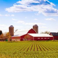 farm with big red barn and two grain silos