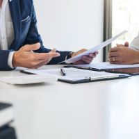 agent and policyholder reviewing insurance policies